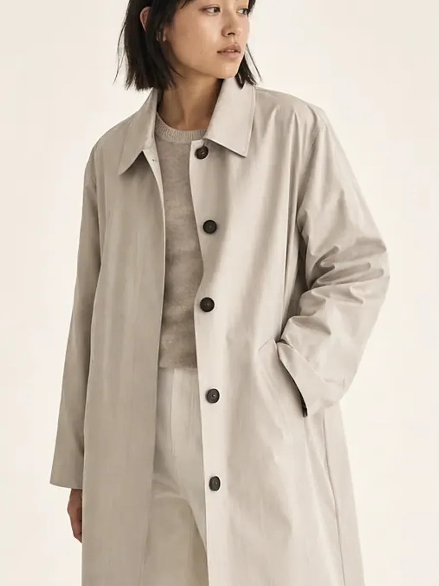 Model wearing a light neutral overcoat